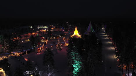 Drone-Night-View-of-Santa-Claus-Village-and-Back-Street,-Finland,-Panning-Shot
