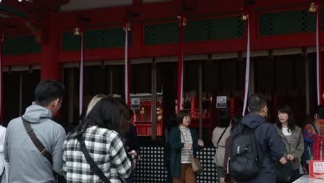 Turistas-Haciendo-Cola-Ante-Las-Campanas-Para-Tocarlas-Y-Rezar-Por-El-Bienestar-En-Kioto,-Japón.