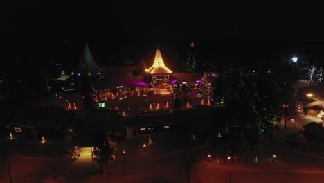 Luftaufnahme-Der-Beleuchteten-Weihnachtsbeleuchtung-Des-Weihnachtsmanndorfes-Bei-Nacht,-Parallaxenaufnahme