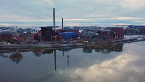 Aerial-view-of-the-Ruoholahti-district-in-Helsinki,-with-reflecting-water---tracking,-drone-shot