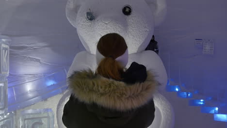 Kids-Having-Fun-Playing-Ice-Teddy-Bear-Slide-and-Mum-Takes-Photo,-Snow-Village,-Lapland-Hotel,-tilt-up