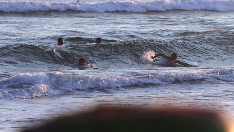 Happy-Kids-Swimming-on-Ocean-Waves-at-Sunset,-Slow-Motion