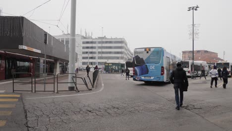 Crowded-bus-station-in-Venice,-Woman-in-blue-protective-face-mask-passing-by