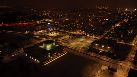 Aerial-view-around-the-illuminated-market-square-of-Oulu,-winter-evening-in-Finland