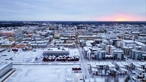 Aerial-tracking-shot-overlooking-the-market-square,-winter-sunset-in-Oulu,-Finland
