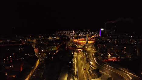 Aerial-view-flying-over-street-toward-the-Naistenlahti-area-Tampere,-night-in-Pirkanmaa,-Finland