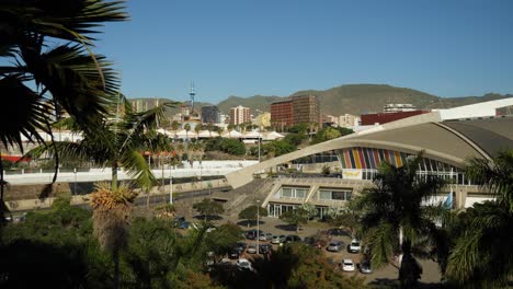 Vista-De-Santa-Cruz-De-Tenerife,-Centro-De-Convención-Cerca-De-Una-Refinería-De-Petróleo,-Palmeras-Alrededor,-Colinas-Al-Fondo