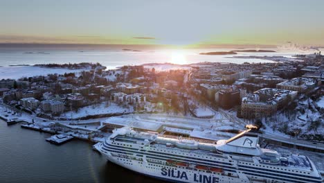 Aerial-tracking-view-of-the-Ullanlinna-area,-winter-sunset-in-Helsinki,-Finland