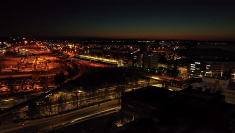 Aerial-view-of-a-train-driving-towards-Tampere-city,-winter-night-in-Pirkanmaa,-Finland