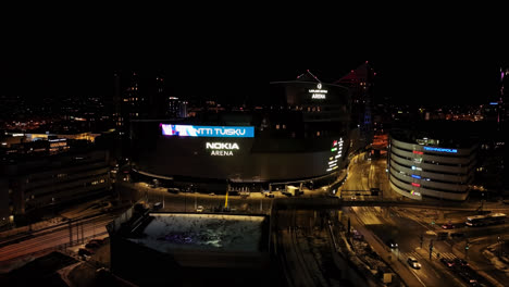 Aerial-view-circling-the-Nokia-arena,-winter-night-in-Tampere,-Finland