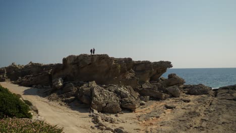 View-of-the-rocky-coast-at-Kallithea-Springs,-Rhodes,-People-walking