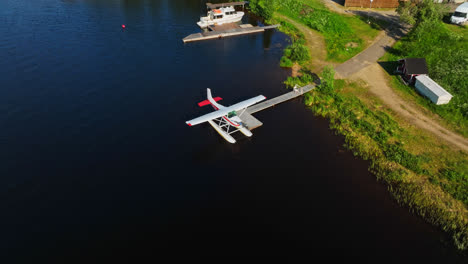 Aerial-view-in-front-of-a-seaplane-docked-at-a-lake-pier,-summer-in-Inari,-Finland
