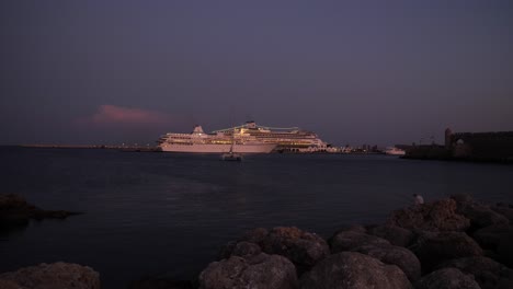 Picturesque-View-Of-Cruise-Ships-Moored-In-The-Harbour-Of-Rodos-Town-At-Twilight