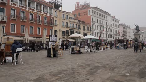 Panning-Footage,-Vendors-And-Street-Painters-At-The-Harbor-In-Venice-Near-St-Mark's-Square,-Days-After-The-Cancelled-Carnival