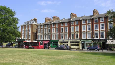 London-Bus-Waits-at-Stop-by-Local-Shops-in-Blackheath-Village,-South-East-London