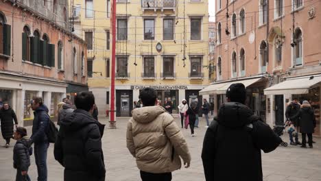Typische-Straßenansicht-In-Venedig-Nach-Der-Absage-Des-Karnevals,-Vater-Mit-Kindern-In-Masken,-Vorbeigehende-Asiatische-Touristen