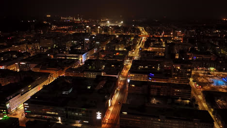 Aerial-tracking-shot-overlooking-night-lit-streets-of-Oulu-city,-winter-in-Finland
