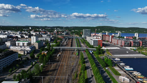 Aerial-view-around-a-train-at-the-railway-station,-sunny,-summer-day-in-Jyvaskyla,-Finland