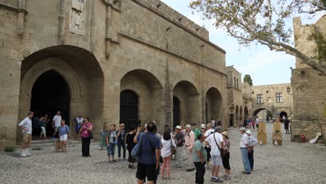 Group-Of-Tourists-Standing-On-The-Square-In-Front-Of-A-Museum-In-The-Old-Town-Of-Rodos,-Rhodes,-Greece