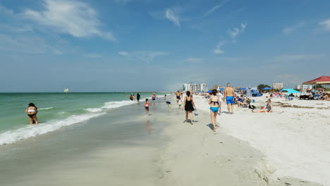 People-Walking-Along-Beach-Shoreline-and-Having-Fun-Swimming-in-the-Ocean-at-Clearwater-Beach,-Florida