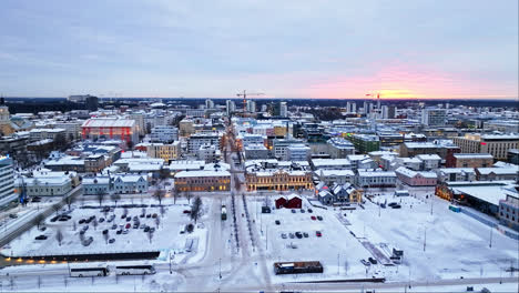 Aerial-tracking-shot-of-the-market-square-and-streets-of-Oulu,-winter-in-Finland