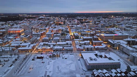 Aerial-tracking-overview-of-downtown-Oulu,-winter-dawn-in-Ostrobothnia,-Finland