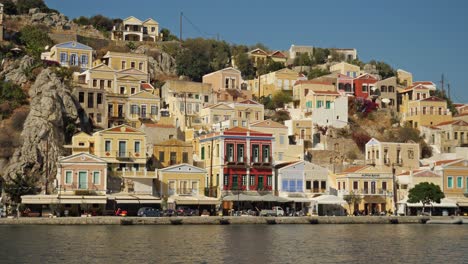 Colorful-houses-on-the-side-of-the-hill-in-Symi-Island-by-the-harbor,-Second-Angle