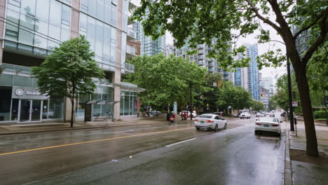 Vehículos-Circulando-Por-Calles-De-Asfalto-Mojado-En-Tiempo-Lluvioso-En-El-Centro-De-Vancouver,-Canadá