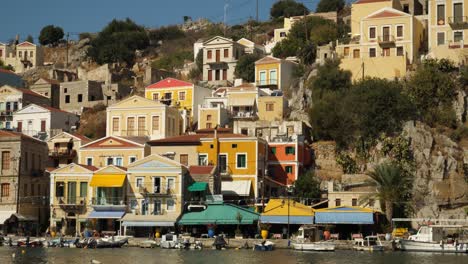 Colorful-houses-on-the-side-of-the-hill-in-Symi-Island-by-the-harbor,-First-Angle