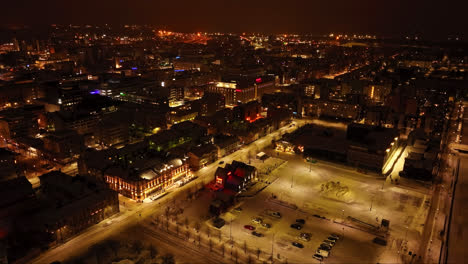 Aerial-view-tilting-over-the-market-square-and-the-cityscape-of-Oulu,-winter-night