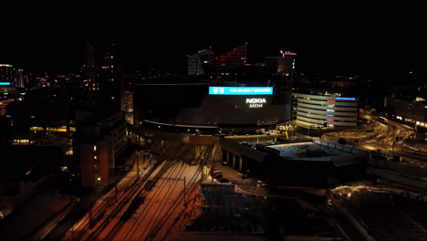 Aerial-view-towards-the-illuminated-Nokia-arena,-winter-evening-in-Tampere,-Finland