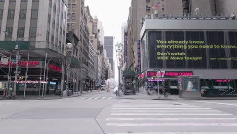 Slow-motion-static-shot-of-lifeless-NYC-midtown-intersection-during-Coronavirus-with-steam-pipes