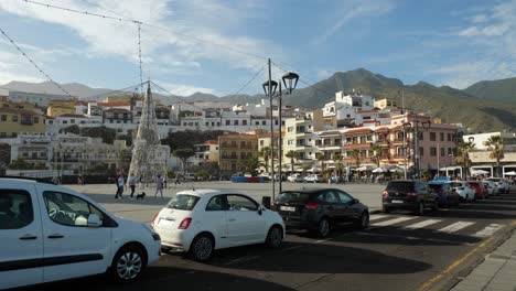 Cars-parking-by-the-square-of-Candelaria,-Townhouses-and-hills-in-background