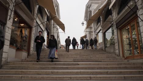 Low-angle-view-of-the-stairs-of-Rialto-Bridge-after-the-cancelled-Carnival,-Asian-couple-walking-down