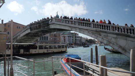 Stone-Bridge-Across-The-Grand-Canal-In-Venice-During-The-Carnival,-Full-Of-People