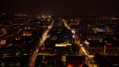 Aerial-tracking-shot-of-quiet,-night-lit-streets-of-Oulu-city,-winter-in-Finland