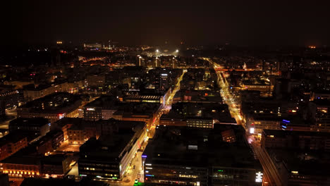 Aerial-view-rotating-over-the-illuminated-downtown-Oulu,-winter-night-in-Finland