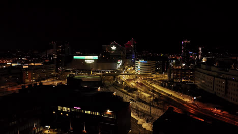 Aerial-view-toward-traffic-in-front-of-the-Nokia-arena,-night-in-Tampere,-Finland