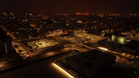 Aerial-view-toward-the-illuminated-market-square-of-Oulu,-winter-night-in-Finland