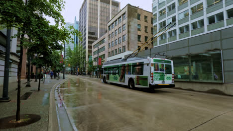 Vancouver-Trolley-Buses-Driving-Along-Street-in-Downtown-in-Rainy-Day,-Public-Transport