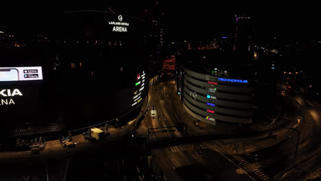 Aerial-view-overlooking-traffic-on-the-Ratapihankatu,-night-in-Tampere,-Finland---reverse,-drone-shot