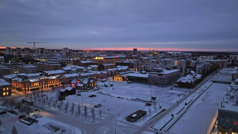 Aerial-view-rising-in-front-of-the-market-square-in-Oulu,-winter-dawn-in-Finland