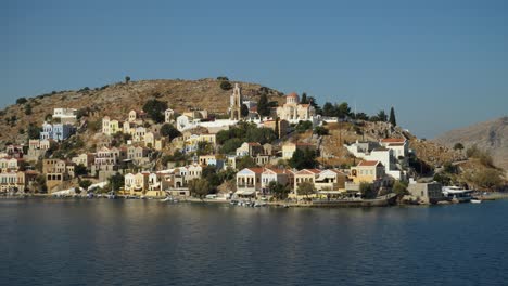 Tracking-aerial-shot-of-the-colorful-harbour-of-Ano-Symi,-Second-Angle