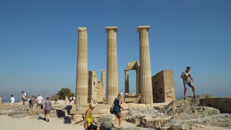 Tourists-at-the-columns-on-the-top-of-the-hill-at-Lindos-Acropolis,-Part-two