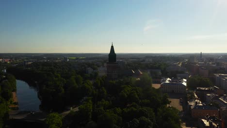 Aerial-view-of-the-Turku-cathedral-and-the-Aurajoki-river,-sunny-summer-morning-in-Proper-Finland---circling,-drone-shot
