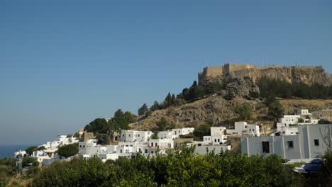 View-of-Lindos-Acropolis-on-top-of-the-hill,-Surrounded-by-white-townhouses