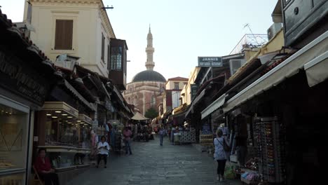 Streetview-in-Rodos-Town-with-gift-and-souvenir-shops,-Mosque-of-Suleiman-at-the-end