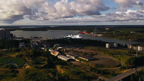 Aerial-view-around-a-Finnlines-cargo-ship-at-the-Naantali-shipping-port,-in-sunny-Finland---circling,-drone-shot