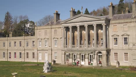 Aerial-of-the-atrium-of-glynllifon-mansion,-various-statues-are-prominent-on-the-lawn