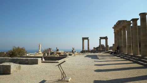 View-of-the-Lindos-Acropolis-and-stone-columns,-With-people